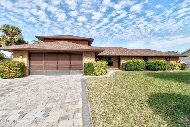 view of front of home with a front lawn and a garage