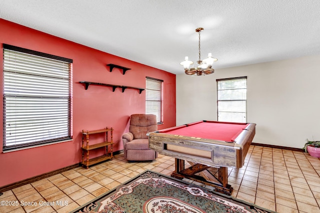 rec room with a textured ceiling, billiards, an inviting chandelier, and light tile patterned floors