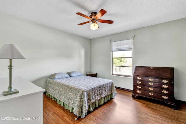 bedroom featuring a textured ceiling, ceiling fan, and hardwood / wood-style floors