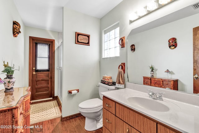 bathroom featuring toilet, vanity, and wood-type flooring