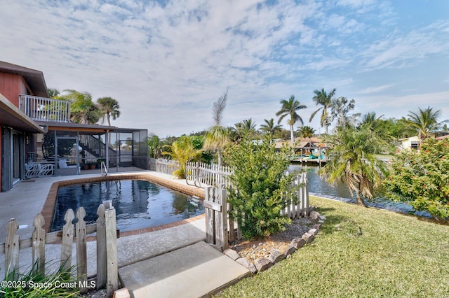 view of pool featuring a lawn, a water view, a sunroom, and a patio area