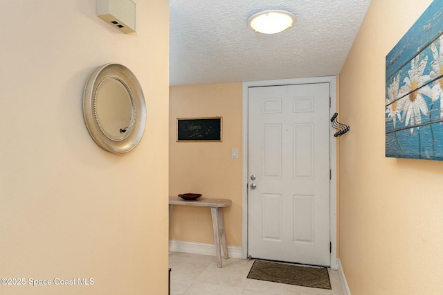 doorway featuring a textured ceiling and light tile patterned flooring