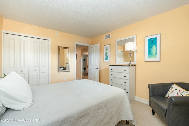 carpeted bedroom with a closet and a textured ceiling