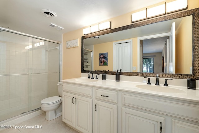 bathroom featuring vanity, toilet, tile patterned floors, and an enclosed shower