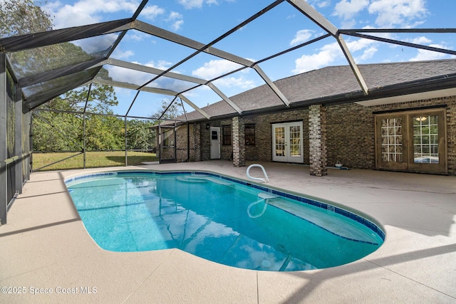 view of pool featuring glass enclosure, a patio, and french doors