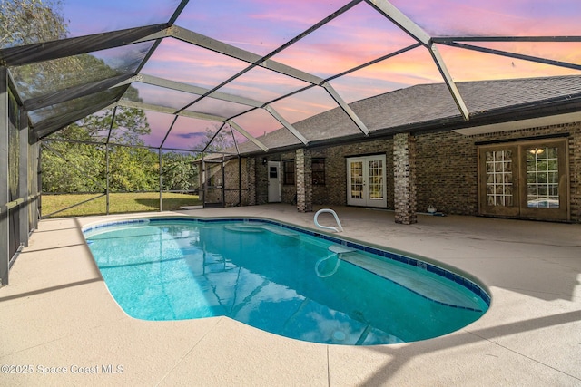 pool at dusk featuring french doors, a patio, and glass enclosure