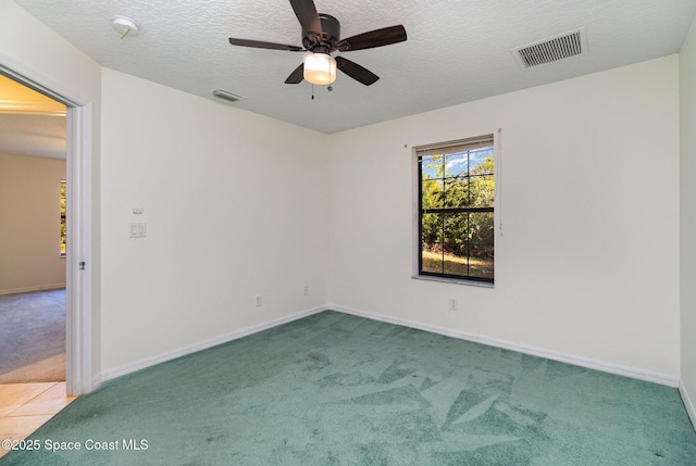 unfurnished room with ceiling fan, carpet floors, and a textured ceiling