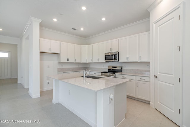 kitchen with a center island with sink, white cabinets, sink, appliances with stainless steel finishes, and light stone counters