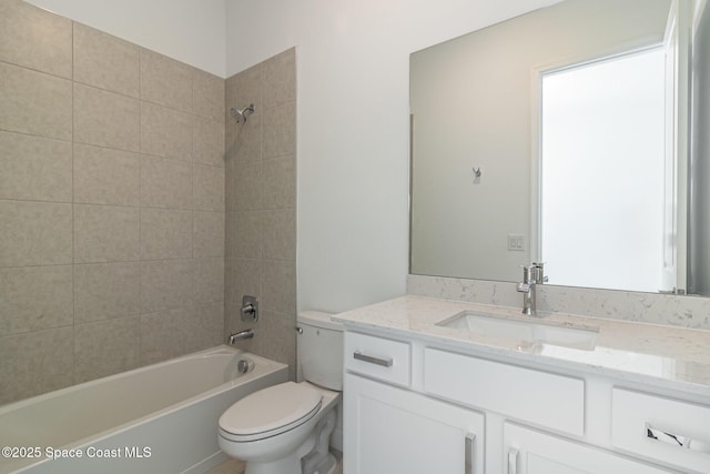 full bathroom featuring vanity, tiled shower / bath combo, and toilet