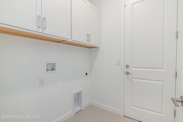 laundry room featuring electric dryer hookup, hookup for a washing machine, light tile patterned flooring, and cabinets