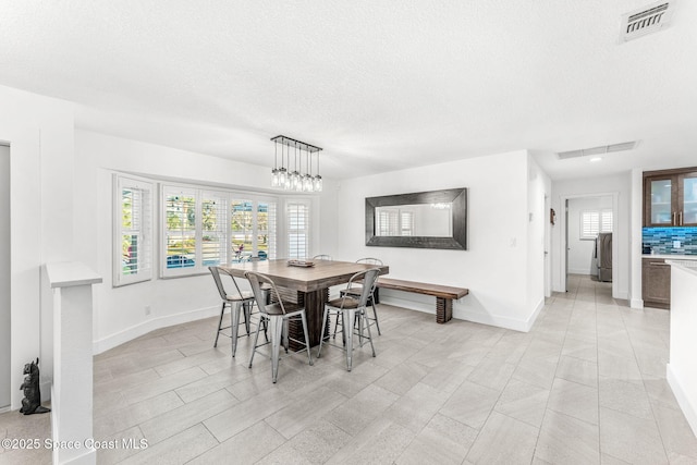 dining room featuring a textured ceiling and a notable chandelier