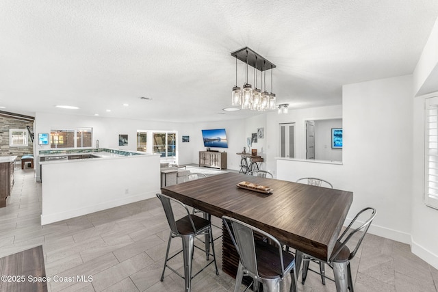 dining area with a textured ceiling and light tile patterned flooring