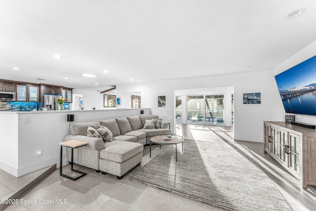 living room with a textured ceiling and light tile patterned flooring