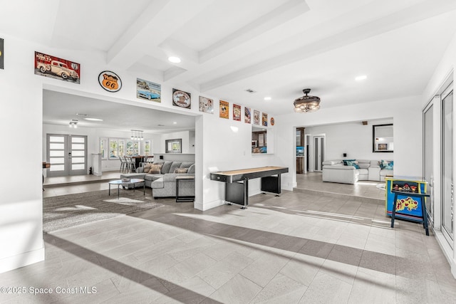 tiled living room featuring beam ceiling and french doors