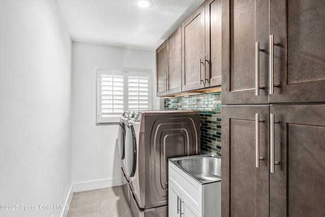 washroom with separate washer and dryer, cabinets, and a textured ceiling