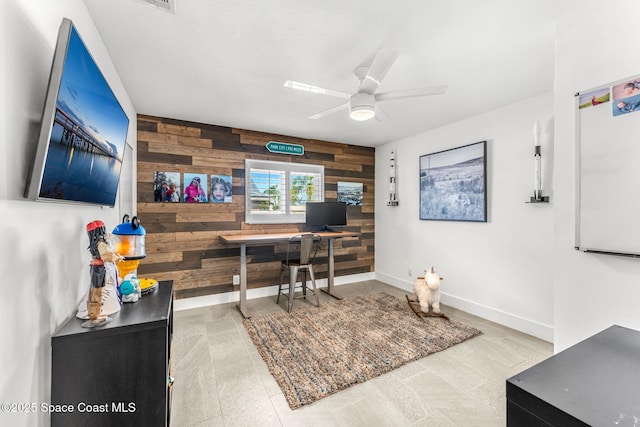 office featuring ceiling fan and wooden walls