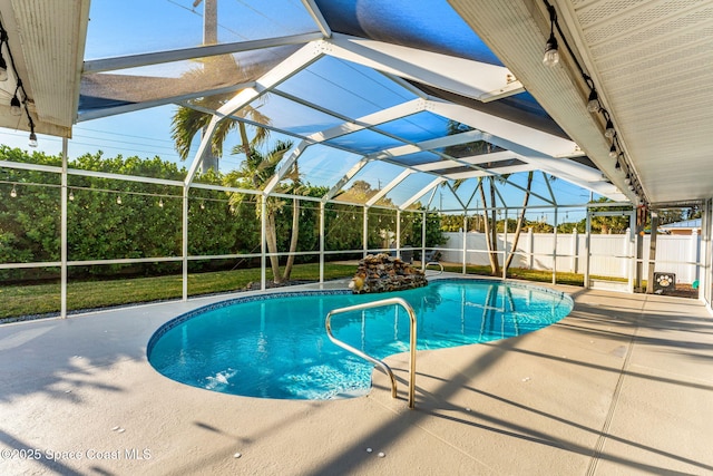 view of pool featuring glass enclosure and a patio