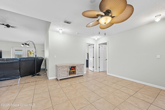 interior space with a textured ceiling, french doors, and light tile patterned flooring