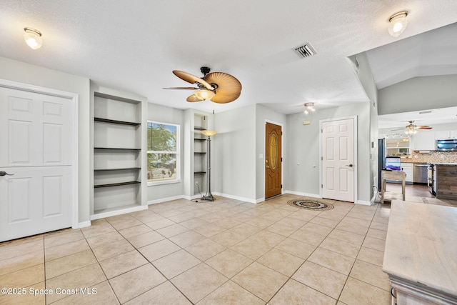 unfurnished living room featuring a textured ceiling, built in features, and light tile patterned flooring