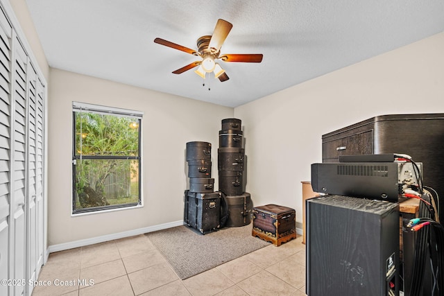 tiled home office featuring ceiling fan and a textured ceiling