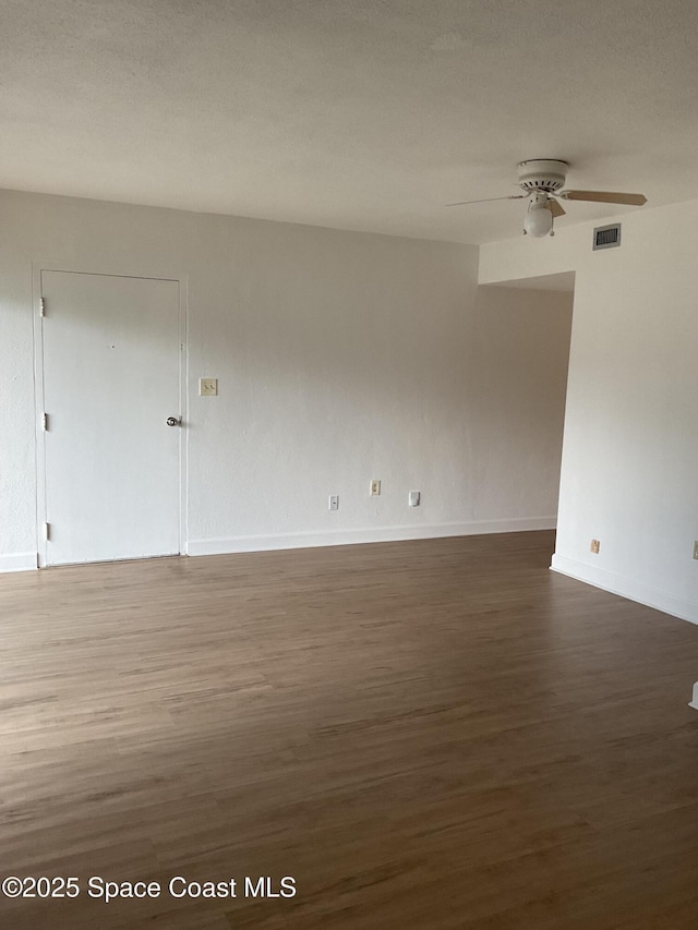 empty room with dark hardwood / wood-style flooring and ceiling fan