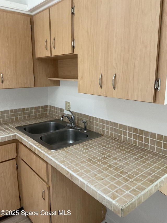 kitchen featuring tile countertops, sink, and light brown cabinetry