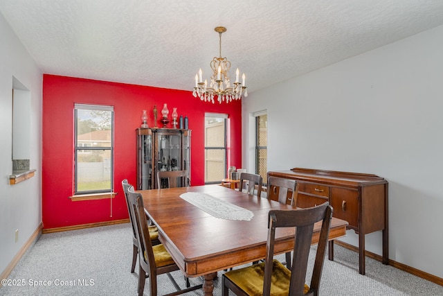 dining room with light carpet, a chandelier, and a textured ceiling