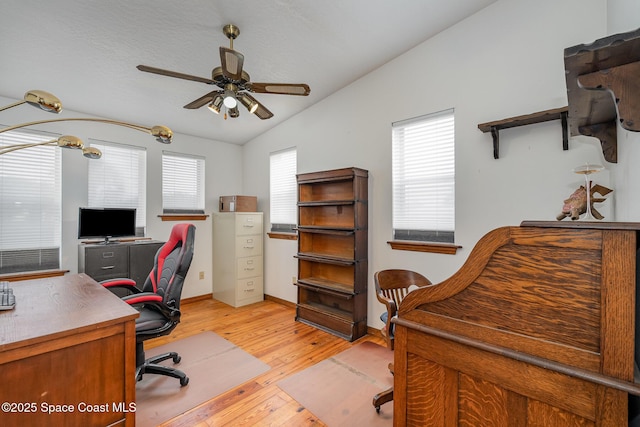 home office featuring vaulted ceiling, ceiling fan, and light hardwood / wood-style floors