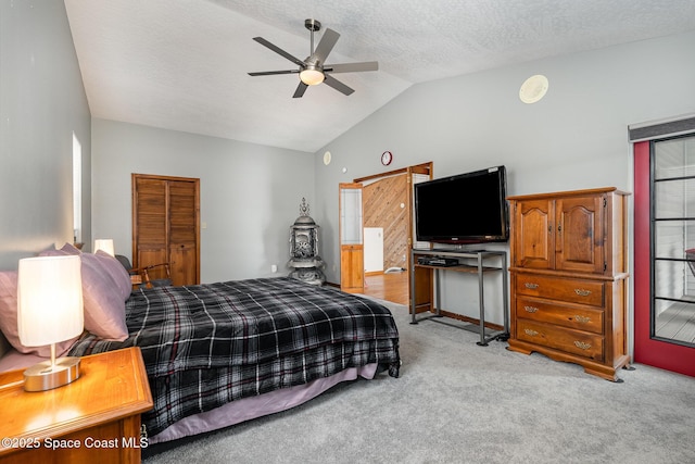 carpeted bedroom featuring ceiling fan, vaulted ceiling, and a textured ceiling