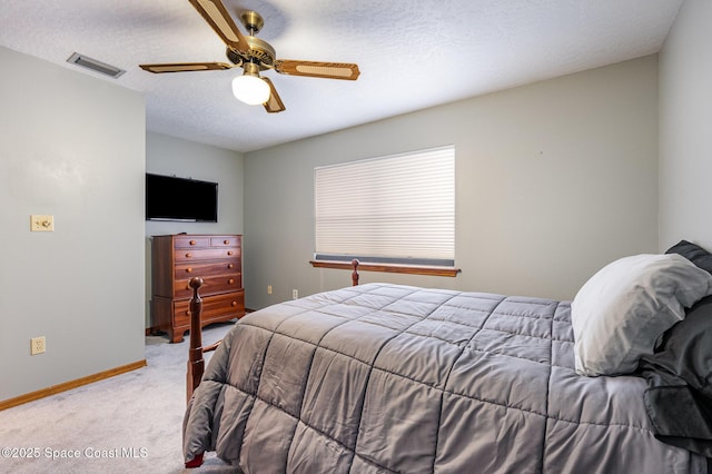 carpeted bedroom with ceiling fan and a textured ceiling