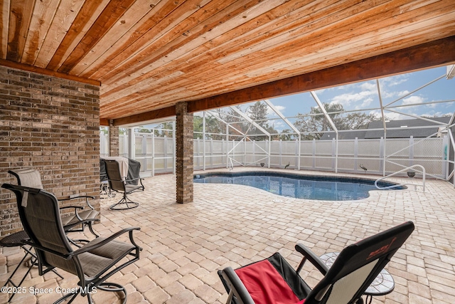 view of swimming pool featuring a patio area and glass enclosure