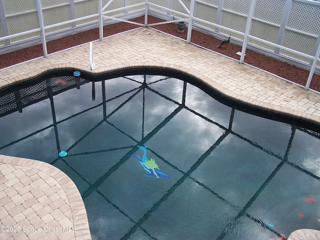 view of swimming pool featuring glass enclosure