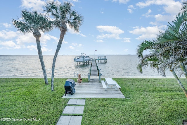 dock area featuring a lawn and a water view