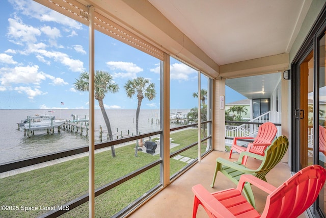 sunroom featuring a water view