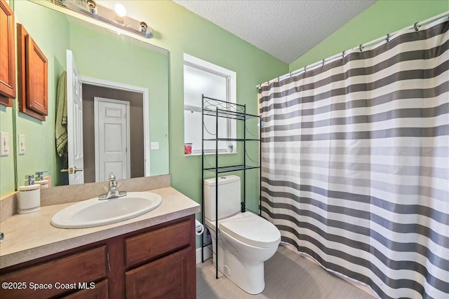 bathroom featuring vanity, toilet, and a textured ceiling