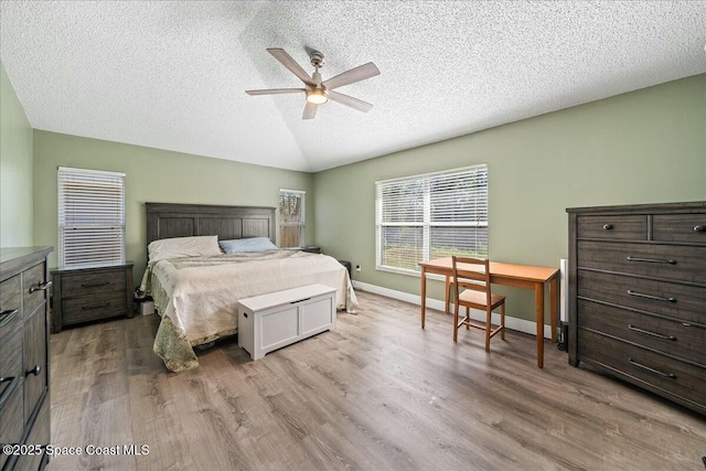 bedroom featuring a textured ceiling, light hardwood / wood-style flooring, ceiling fan, and lofted ceiling