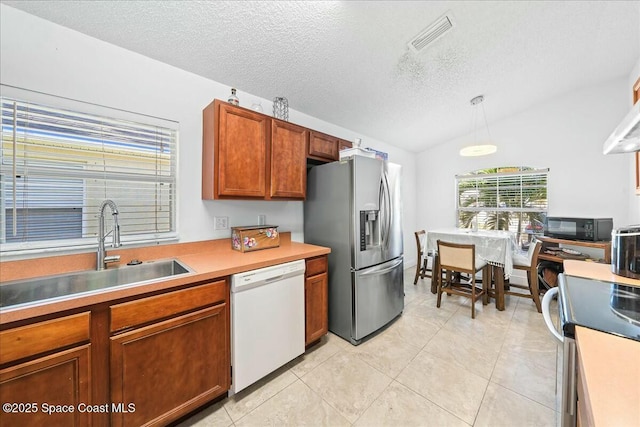 kitchen featuring dishwasher, sink, hanging light fixtures, stainless steel fridge with ice dispenser, and a textured ceiling