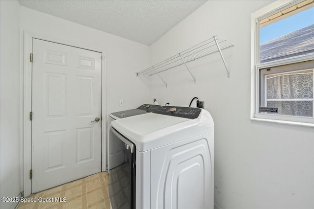 laundry room featuring washer and dryer and a textured ceiling