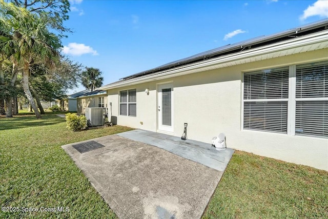 rear view of property featuring a yard, cooling unit, a patio, and solar panels