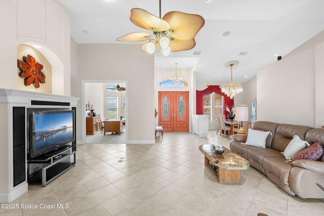 living room with light tile patterned floors and ceiling fan with notable chandelier