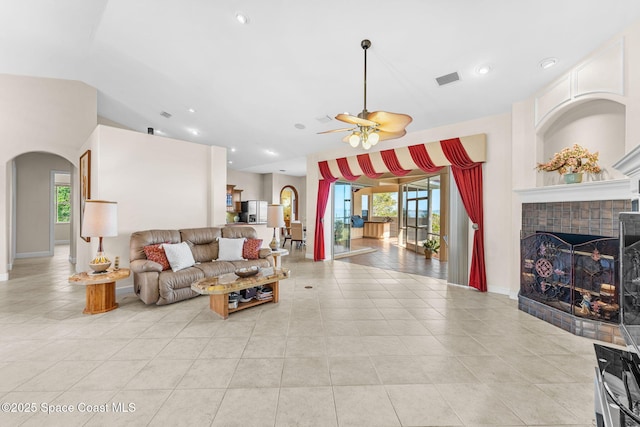 living room featuring lofted ceiling, light tile patterned floors, and ceiling fan