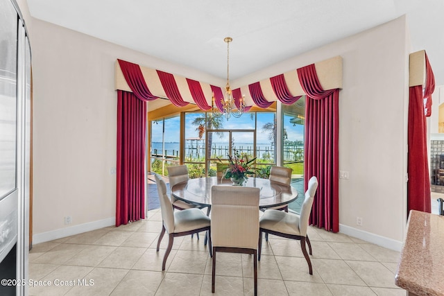 dining area with light tile patterned flooring, a water view, and a wealth of natural light