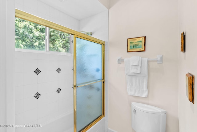 bathroom with shower / bath combination with glass door and toilet