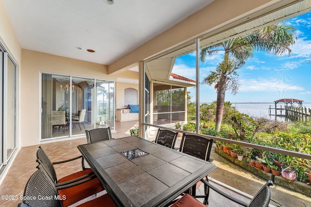 sunroom featuring a water view