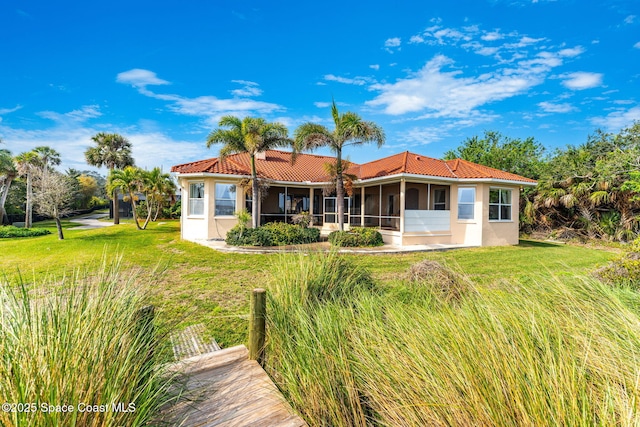 rear view of house with a yard and a sunroom