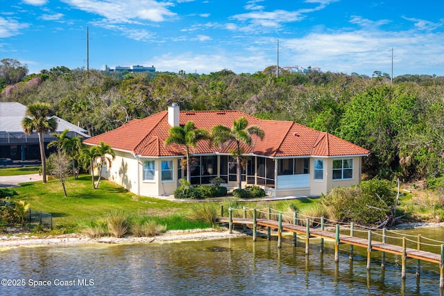 back of house featuring a yard, a sunroom, and a water view