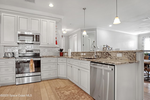 kitchen with hanging light fixtures, kitchen peninsula, appliances with stainless steel finishes, and sink