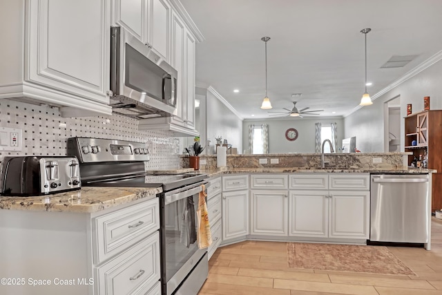 kitchen featuring decorative light fixtures, white cabinetry, appliances with stainless steel finishes, and ceiling fan