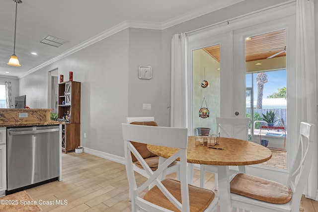 dining room with a wealth of natural light, ornamental molding, and light hardwood / wood-style flooring