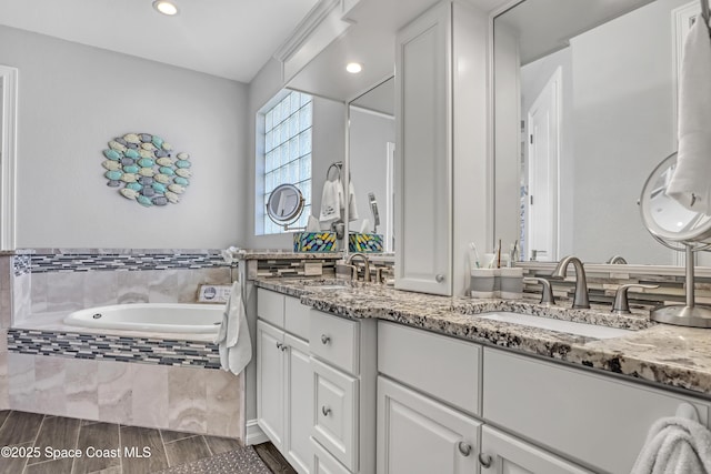 bathroom with a relaxing tiled tub and vanity